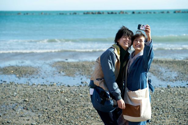 海辺で写真を撮るふたりの姿に癒される