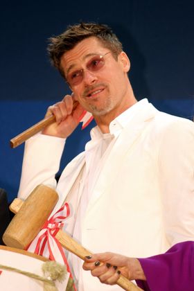 鏡を割る木槌をもっておどけるブラッド・ピット