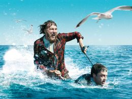 死体のメニ―(ダニエル・ラドクリフ)をジェットスキーにして海を疾走するハンク(ポール・ダノ)