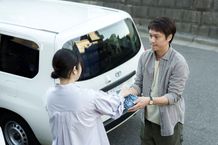 仕事へ向かう金子が美和子から手作りの弁当を受け取り、見送られるシーン