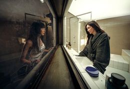 広くて清潔な洗面台の前に立つミジュと薄汚れた暗い空間に立つスヨンが向かい合う