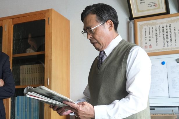 報道された週刊誌の記事を見て、苦い表情を浮かべる段田校長