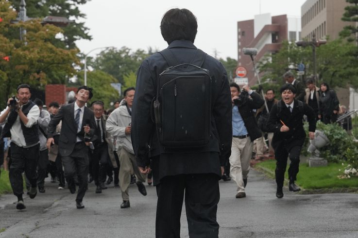 出廷してきた薮下を待ち構える報道陣