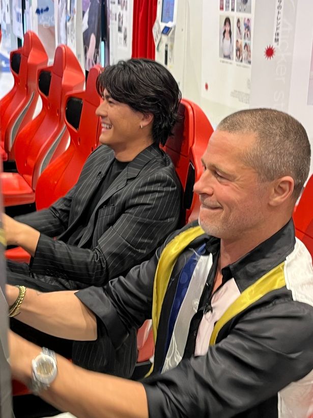 【写真を見る】『F1(R)／エフワン』にちなみ、レーシングゲームで対決したピットと森本