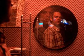 鏡に映るエドワードの表情を切り取った場面写真