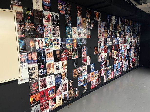 【写真を見る】映画ファン垂涎の映写室！25年間に上映された映画チラシが壁にびっしり