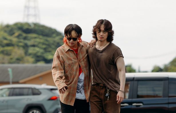 タクヤ(北村匠海)と梶⾕(綾野剛)が肩を寄せ合いながら歩いていく