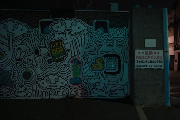 入口の左側には、謎のQRコードと共に不思議な絵が描かれている