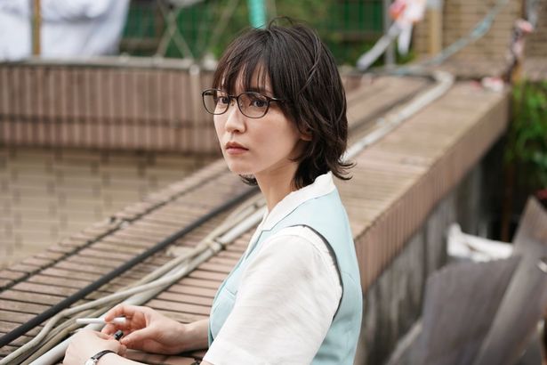 【写真を見る】九龍城砦の街中のとある屋上で過ごす令子