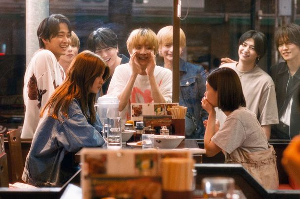 同僚を引き連れたアサヒに店外から声をかけられて戸惑うカット