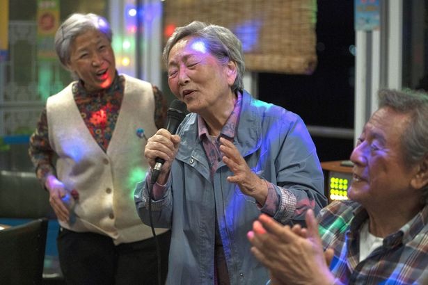旧友たちと再会し、カラオケに興じる(『最後のピクニック』)