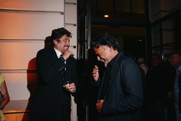 くだけた笑顔で笑い合うベニチオ・デル・トロ(写真左)とアレハンドロ・ゴンサレス・イニャリトゥ(写真右)