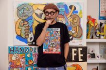 「好き」という意味の韓国手話を見せてくれている門秀彦