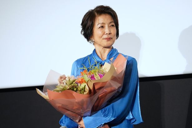 花束を手に笑顔を見せる市毛