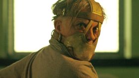 拘束マスクを着用し鋭い視線を向ける男