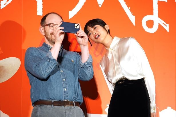 客席の撮影をするアスター監督のスマホを覗き込む河合