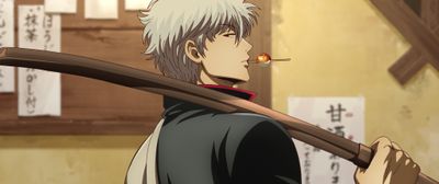 団子を咥え、木刀を肩に担ぎながら鋭い視線を放つ銀時