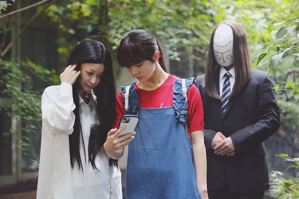 背後に現れるお面姿の“神様”とは？