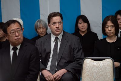 礼服に身を包み、どこか不安げな表情で葬儀に参列する姿