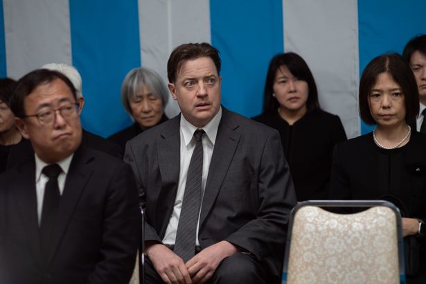 礼服に身を包み、どこか不安げな表情で葬儀に参列する姿