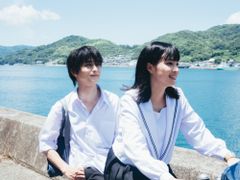 瀬戸内の美しい海を背に、制服を纏って自転車を2人乗りする姿