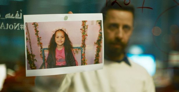 【写真を見る】オフィスのガラスに貼られたヒンド・ラジャブの写真