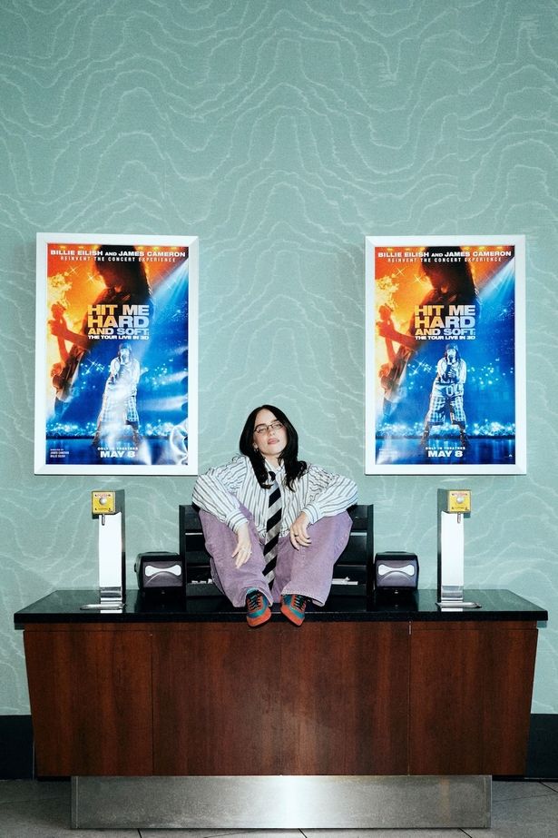 【写真を見る】ポスターと並んだビリー・アイリッシュの最新ショット