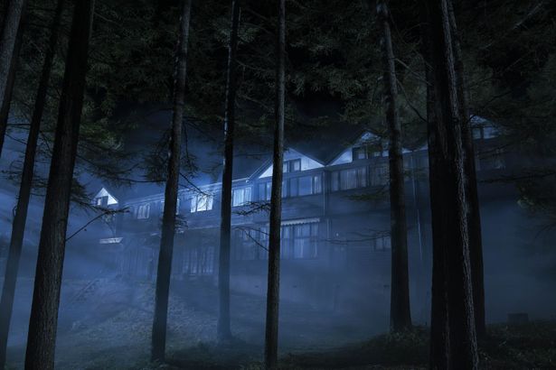 深い霧に包まれた夜の洋館の全景