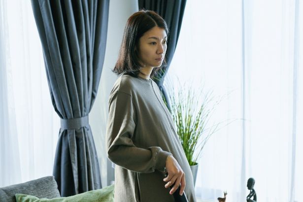 複雑な表情を浮かべる妊娠中の妻、菊子
