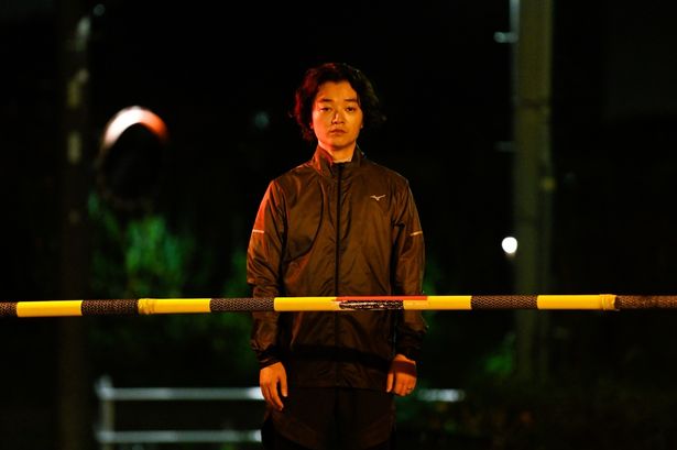 踏切の前に佇む漆原