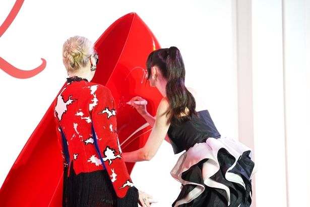 ビッグハイヒールにサインをするハサウェイ