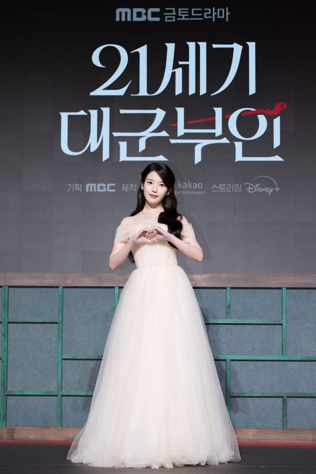 ハートで報道陣に応えるIU