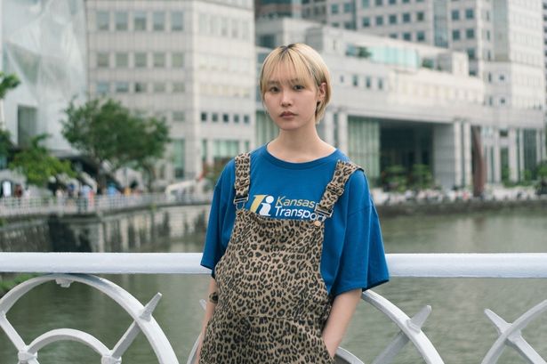 シンガポールの橋の上に立っている麻由