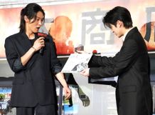 映画『SAKAMOTO DAYS』(公開中)の初日舞台挨拶で原作者の鈴木祐斗による描き下ろしイラストがサプライズでプレゼントされ驚きの表情を見せる主演の目黒蓮