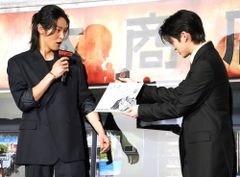 映画『SAKAMOTO DAYS』(公開中)の初日舞台挨拶で原作者の鈴木祐斗による描き下ろしイラストがサプライズでプレゼントされ驚きの表情を見せる主演の目黒蓮
