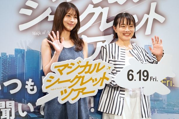 手を振りながらカメラにニッコリ