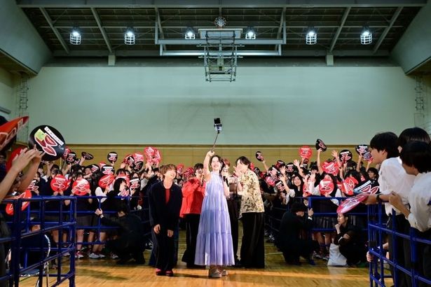 自撮り棒を使って生徒たちと360度記念撮影を行うMOMONA