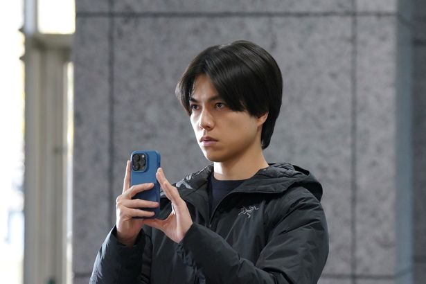 鋭いまなざしでスマートフォンを向ける航