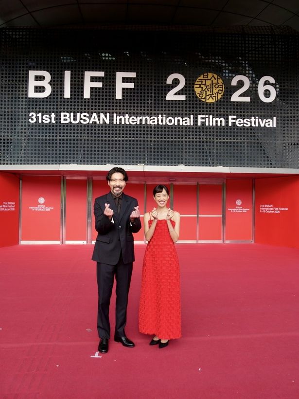 「BIFF」の大型ロゴをバックに、お茶目に指ハートを贈る柄本佑と石橋静河