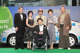 日系人兵士に車椅子を押され、すずきじゅんいち監督が登壇