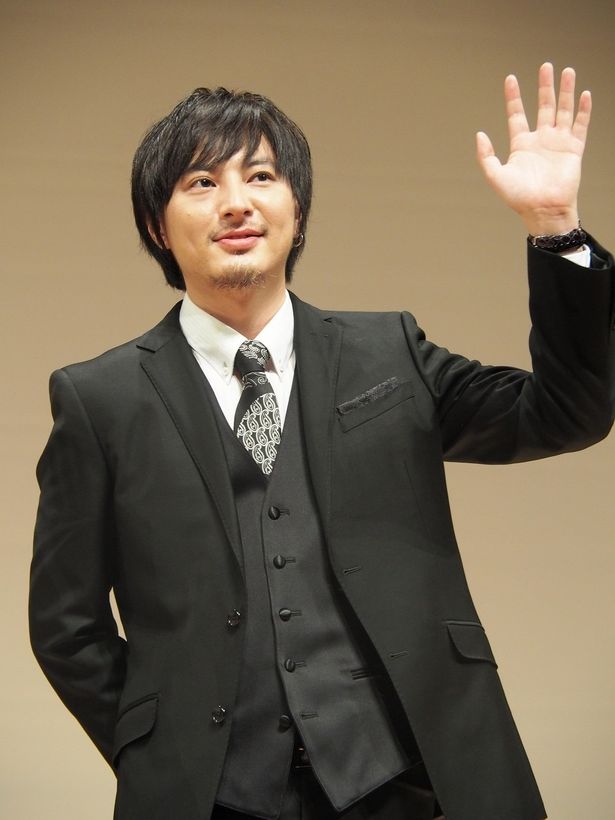 会場に集まった観客に手を振る塚本