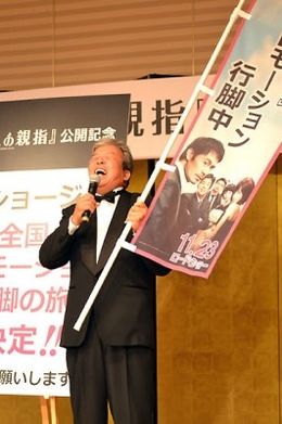 宣伝用ののぼりを渡され、全国行脚することになった村上ショージ