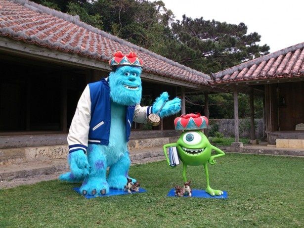 沖縄を代表するシーサーと記念撮影。シーサーの小ささがサリーとマイクの巨大さを物語る