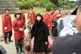 空飛ぶシーンの撮影中、強風で目に入る砂埃と格闘するキキ役の小芝風花