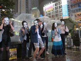 ジョブズのお面を被り、特別映像を見る人々