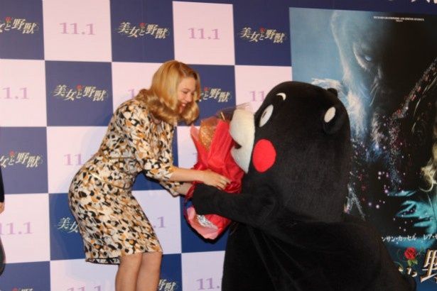 ひざまずいてレア・セドゥに花束を渡すくまモン