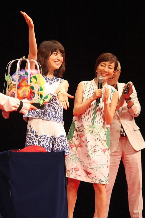 【写真を見る】「なんじゃ、もんじゃ、ミージャ！」とおまじないをかけ、白いハンカチをカラフルなハンカチや花束に変えた大島優子