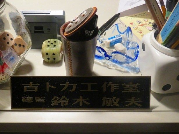 答えは鈴木敏夫プロデューサー！デスクの上にはコレクションのサイコログッズがいっぱい！