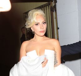 胸元を大胆に露出する白いドレスで現れたレディー・ガガ