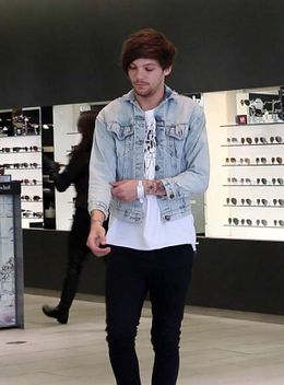 白いバンドを腕に巻いて歩くルイ・トムリンソン